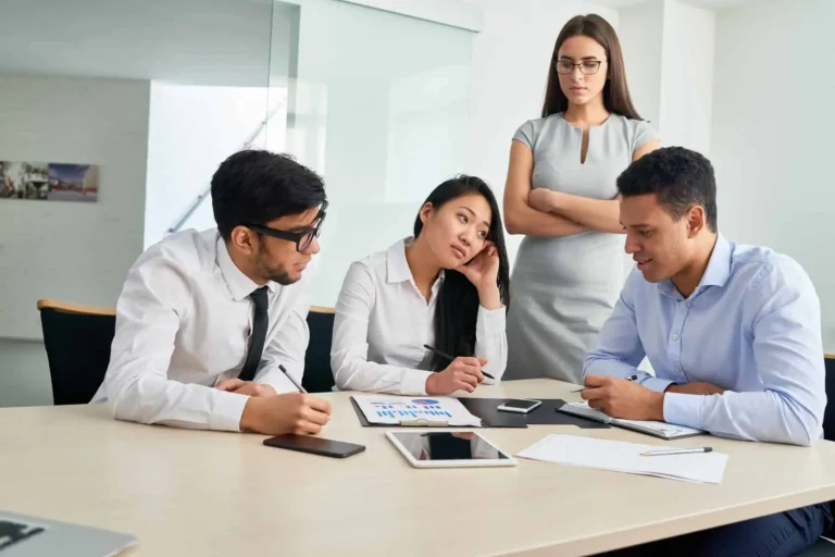 People talking in front of their boss, illustrating strategies to handle a difficult manager effectively