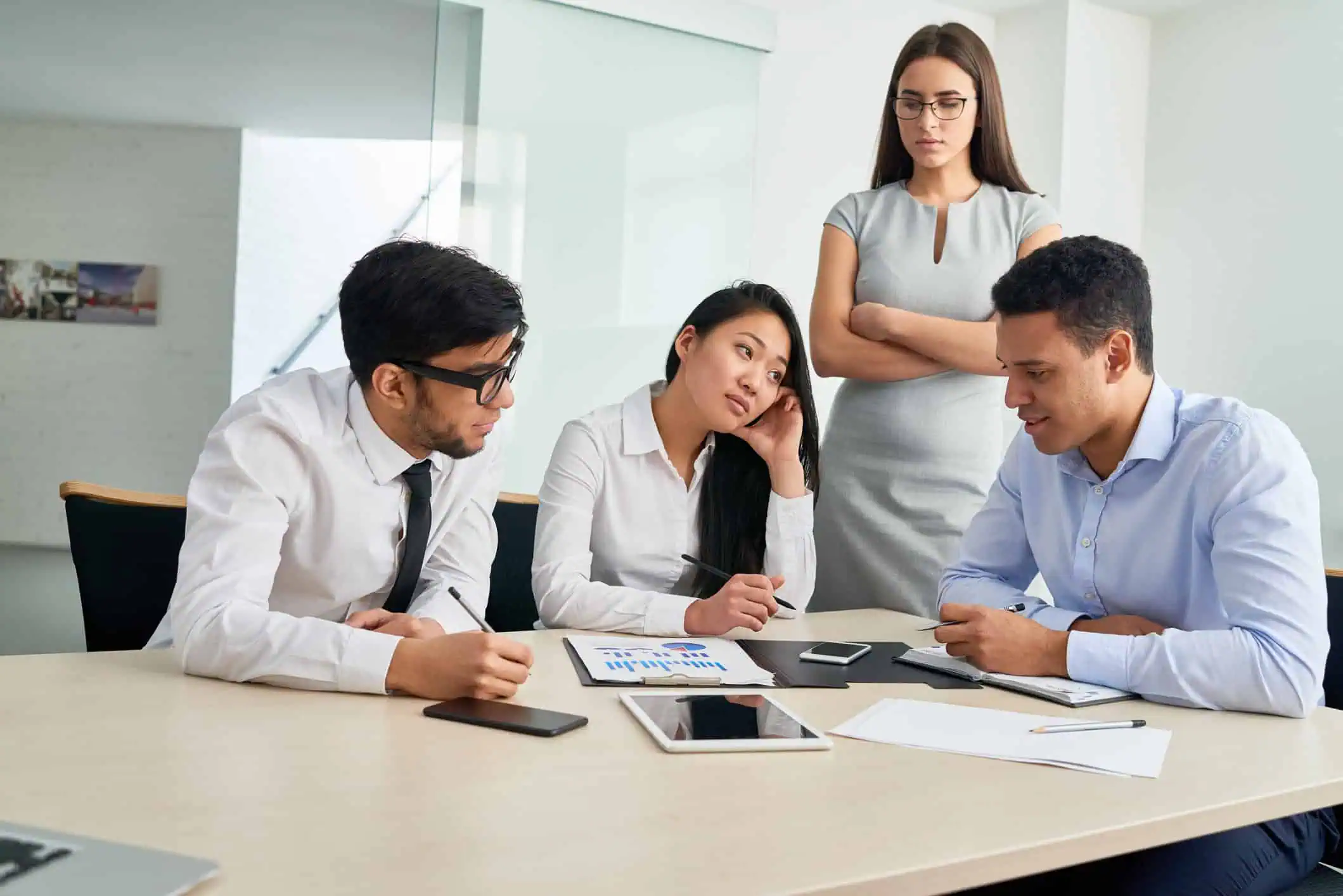 People talking in front of their boss, illustrating strategies to handle a difficult manager effectively