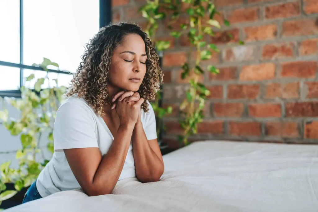 Woman praying image illustrating ways to manage fear with faith and guidance.