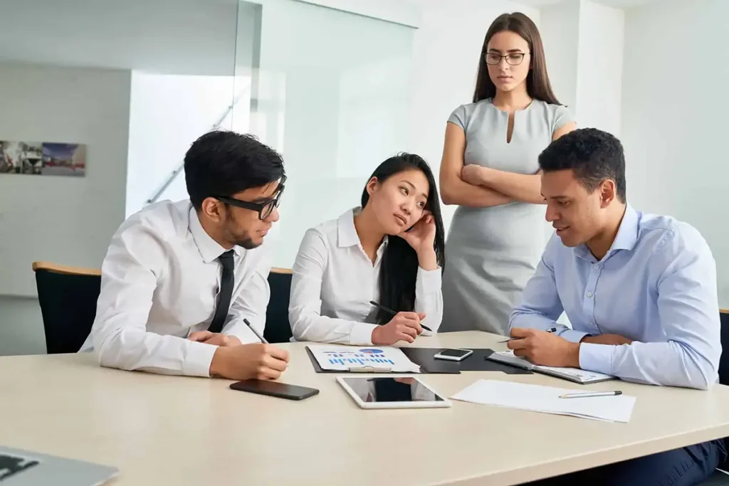 People talking in front of their boss, illustrating strategies to handle a difficult manager effectively