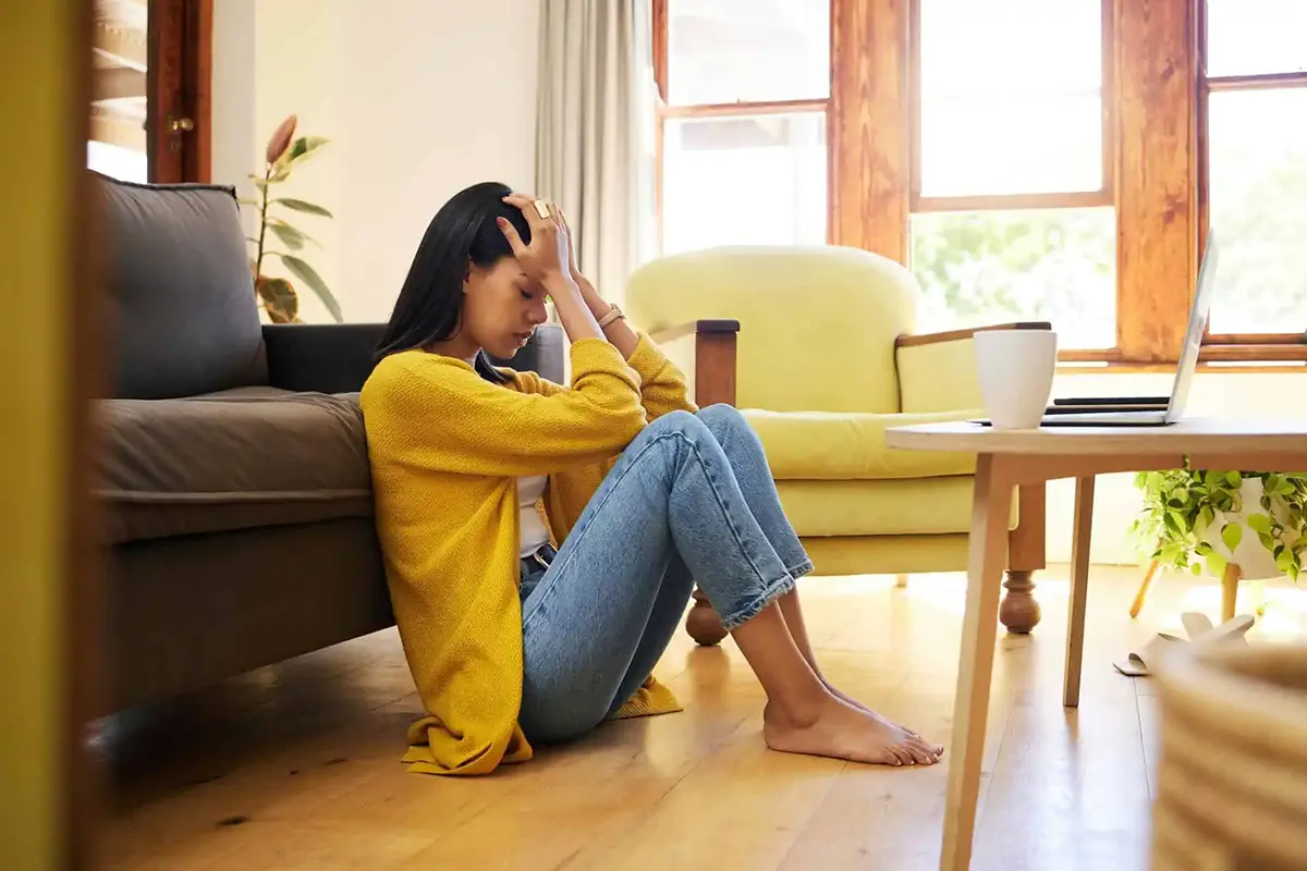 Image of person sitting on floor for article on stress management techniques