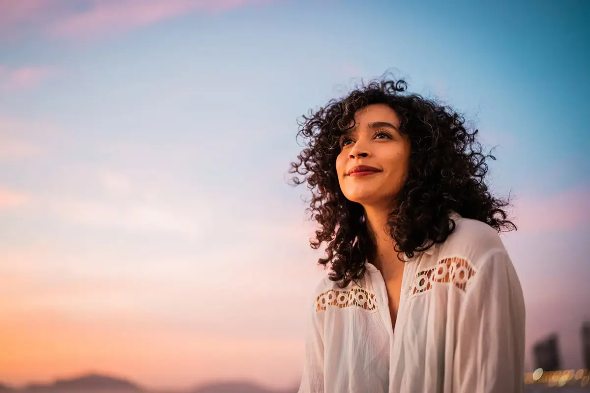 Woman smiling at the sky, illustrating tips for managing fear of the unknown effectively